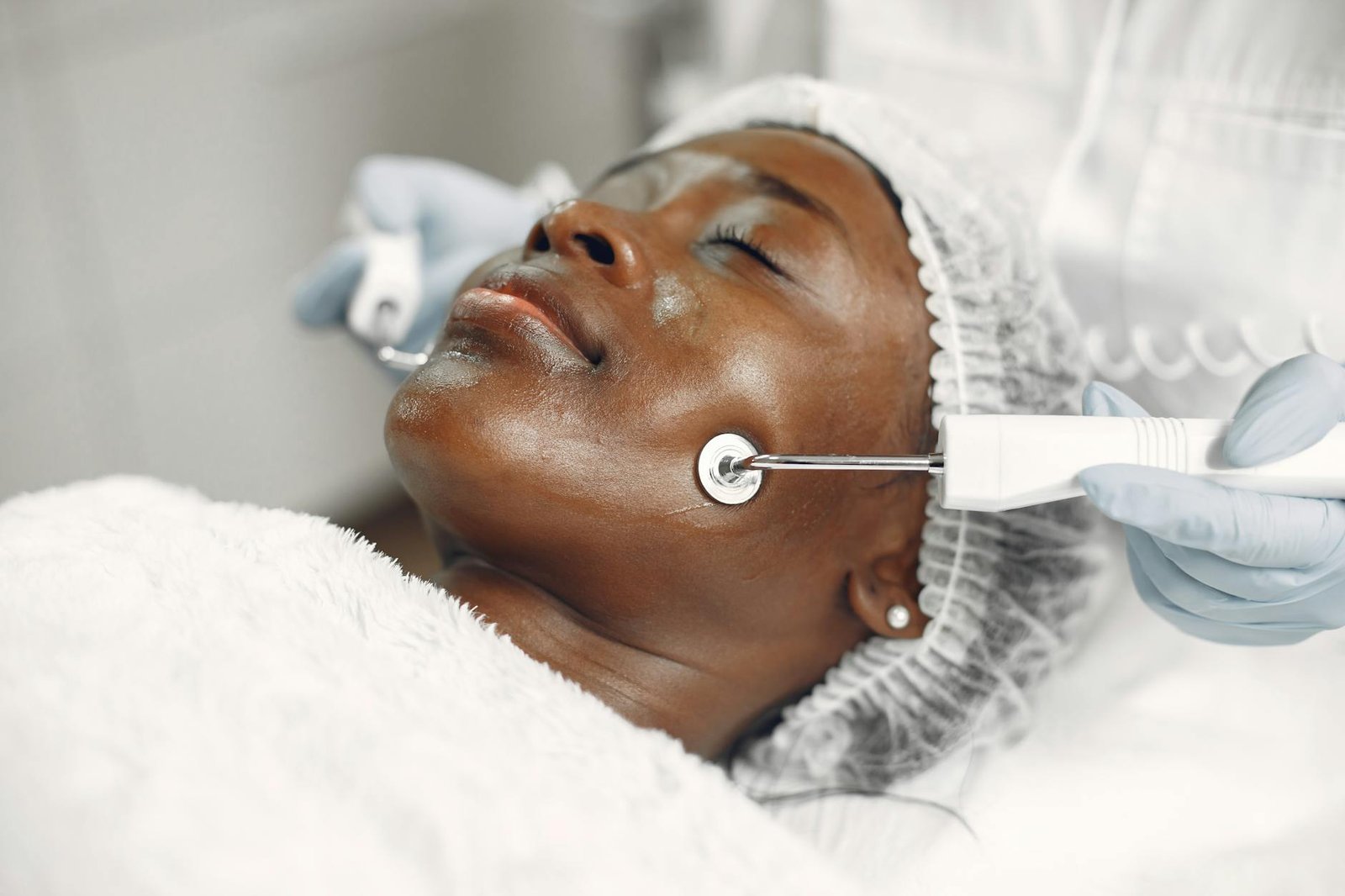 A woman receives a facial microcurrent treatment at a spa. Relaxing and rejuvenating skincare.